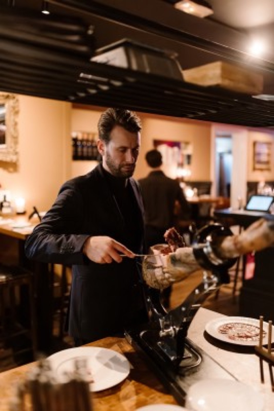 Gastheer schenkt wijn in aan de bar